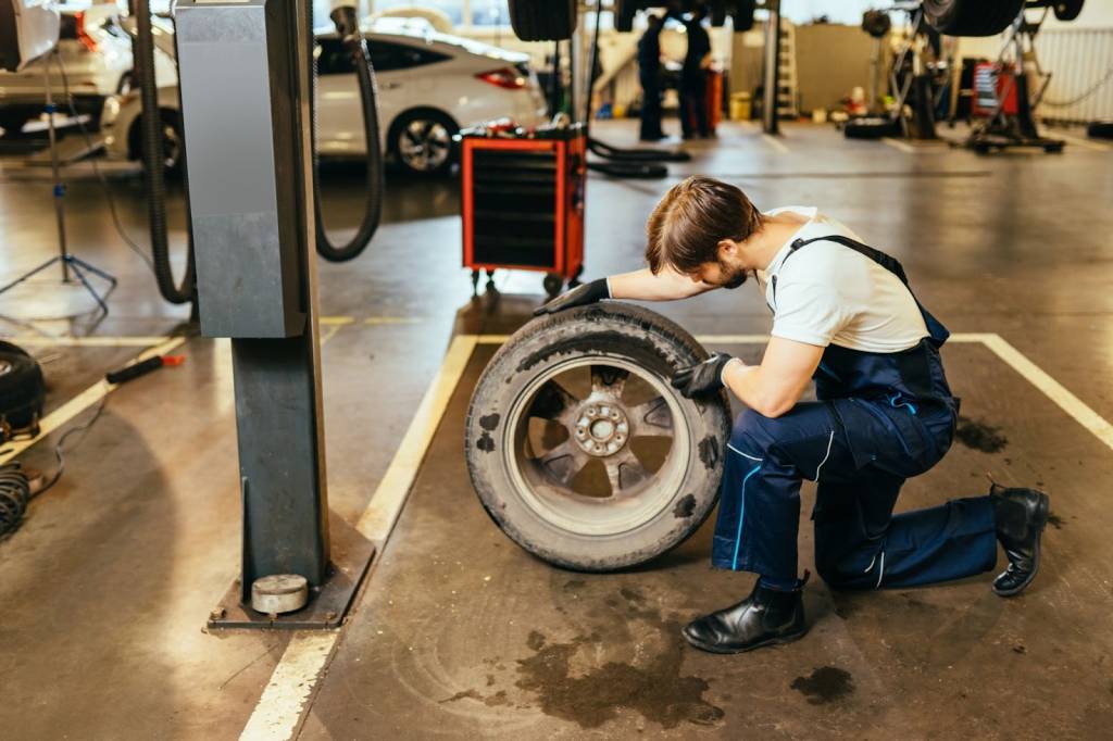 A mechanic thoroughly inspects a vehicle’s tire for wear or damage.