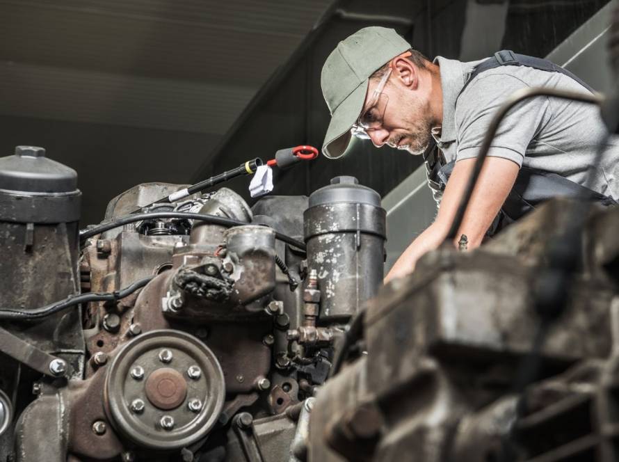 Skilled mechanic performing diesel engine restoration on a truck