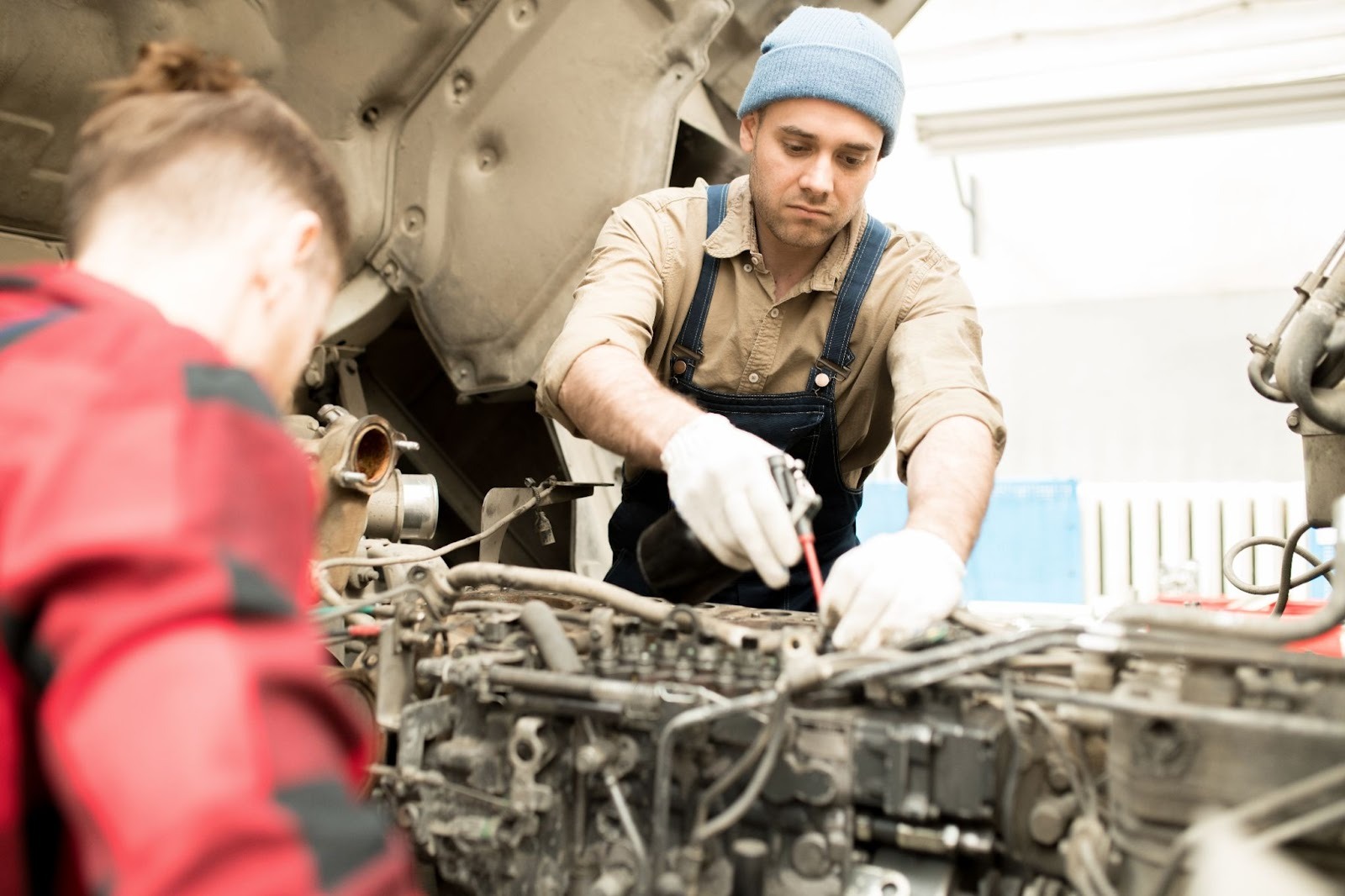 Auto technicians working on a diesel engine during scheduled maintenance