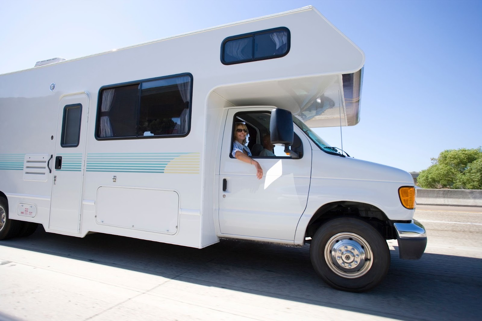 Side angle of a woman in sunglasses enjoying a bright day inside an RV