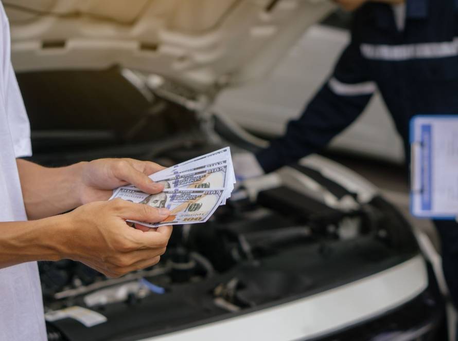 Customer preparing cash payment for exhaust system repair at an auto service center