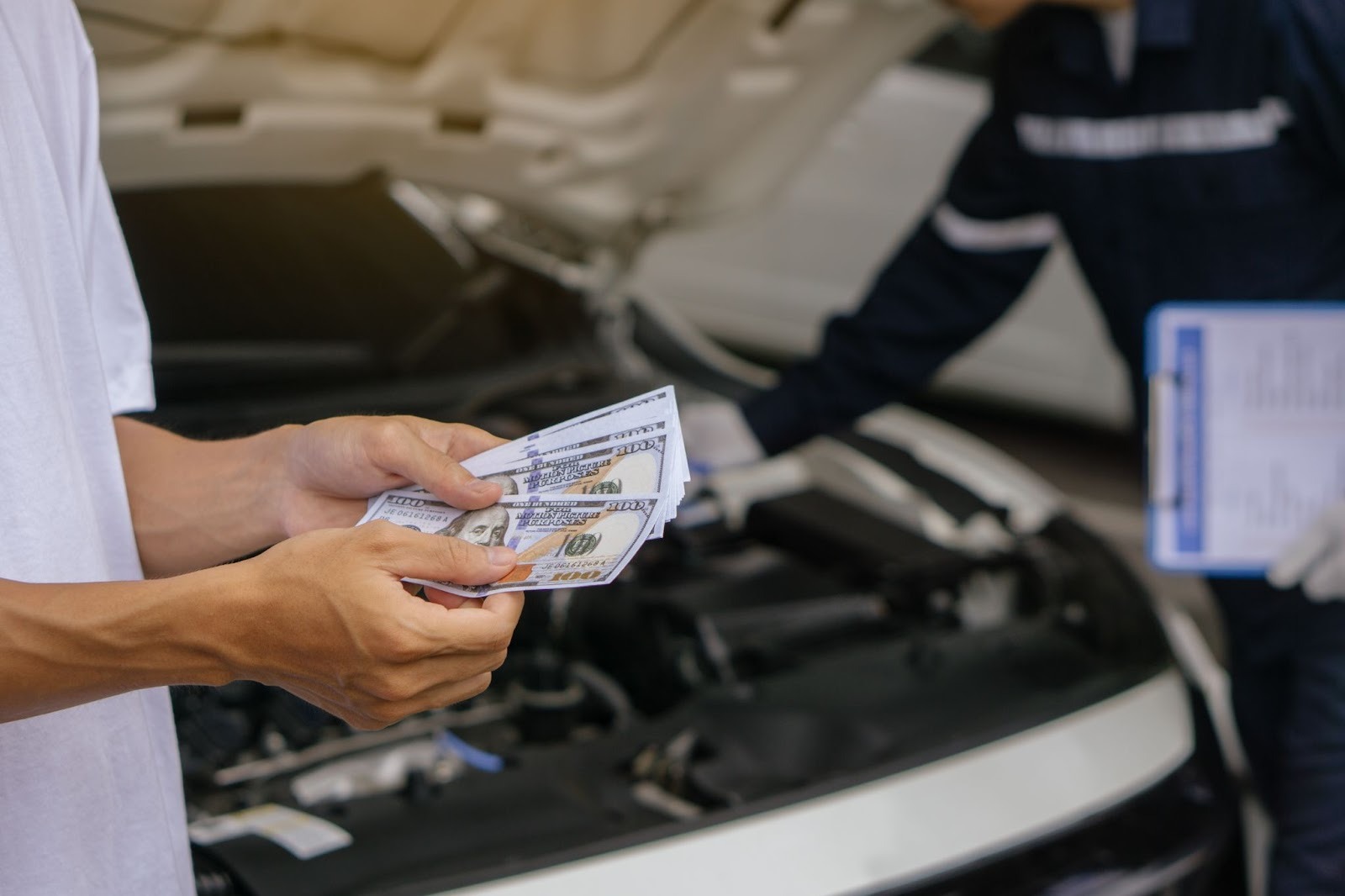 Customer preparing cash payment for exhaust system repair at an auto service center
